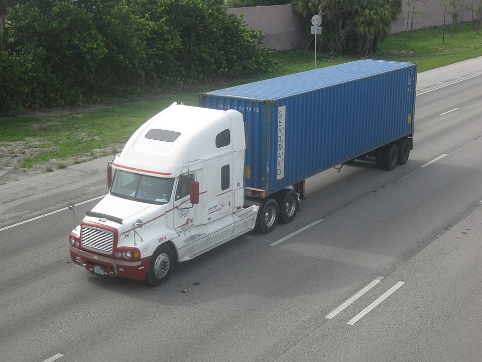 Freight truck hauling a shipping container on the highway