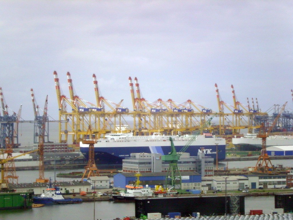 Aerial view of a container ship docked among gantry cranes